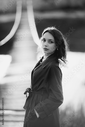 beautiful brunette european girl in blue trench coat at nature. Young lady with beautiful face and lips.