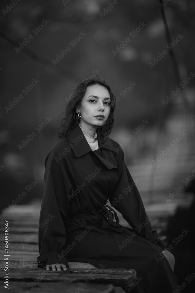 beautiful brunette european girl in blue trench coat at nature. Young lady with beautiful face and lips.