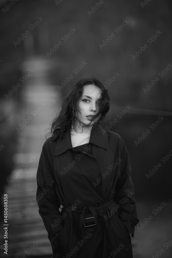 beautiful brunette european girl in blue trench coat at nature. Young lady with beautiful face and lips.