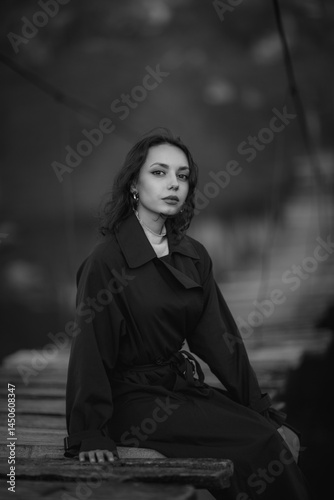 beautiful brunette european girl in blue trench coat at nature. Young lady with beautiful face and lips.