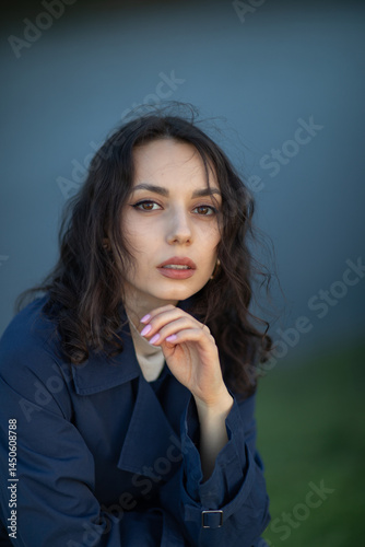 Obraz na płótnie beautiful brunette european girl in blue trench coat at nature. Young lady with beautiful face and lips. w salonie