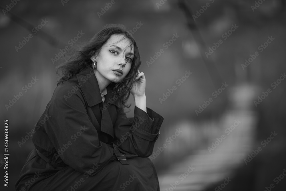 beautiful brunette european girl in blue trench coat at nature. Young lady with beautiful face and lips.