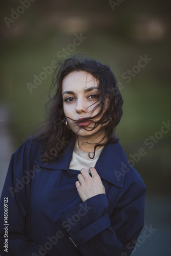 Obraz na płótnie beautiful brunette european girl in blue trench coat at nature. Young lady with beautiful face and lips. w salonie
