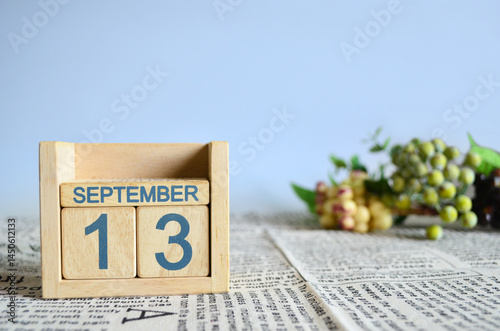 September 13, Calendar cover design with number cube with fruit on newspaper fabric and blue background.	