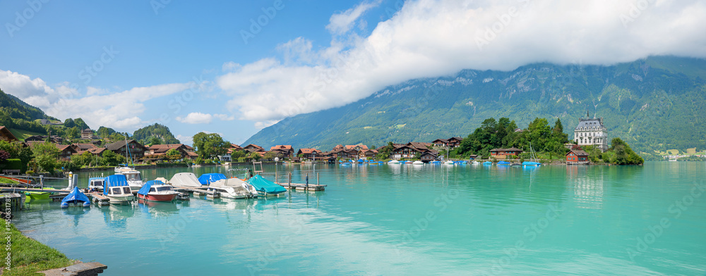 harbor with moored boats, tourist resort Iseltwald, lake Brienzersee, switzerland