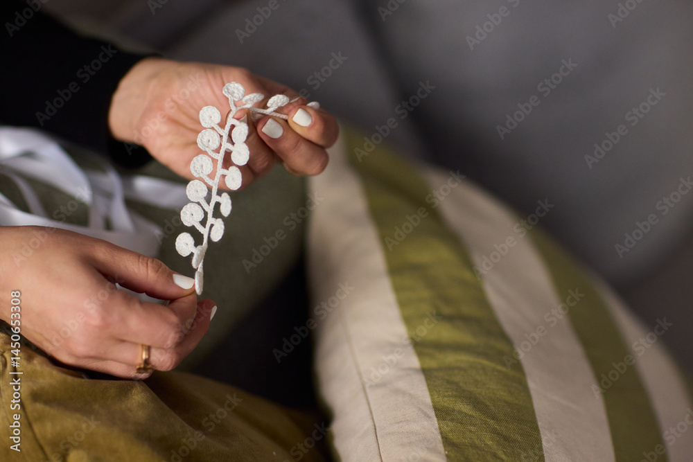 Closeup of hands with colorful beads on a cozy couch, showcasing handmade decor elegance