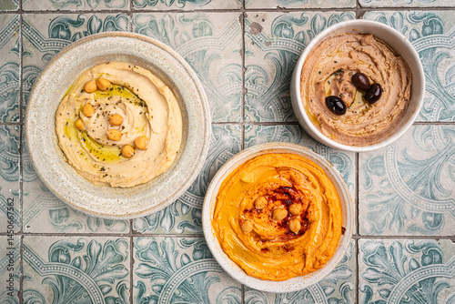 Obraz na płótnie Various hummus dips in different colours. Hummus with dry crackers, top view. Vegan and traditional hummus as healthy and vegan snack. w salonie