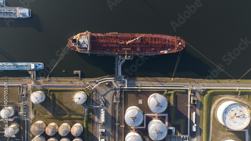 Top down view on petroleum ship loading and unloading terminal. Storage silos for gas, liquids. Tanker in port. Shipping global logistics. photo