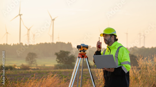 Wallpaper Mural A field engineer surveys the land at sunset, with wind turbines behind as technology meets clean energy. Torontodigital.ca