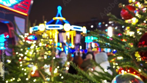 Festive blurred night at illuminated holiday market with lights and decorations