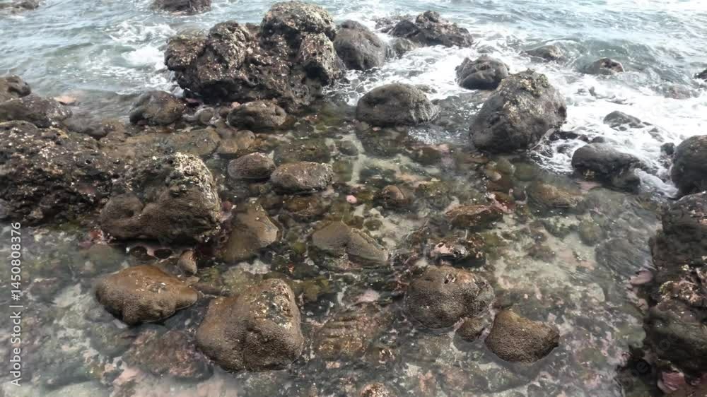 Top view of calm waves on the rocks of the beach. For transition or relaxation videos. Ecology and environmental concept. Footage 4K, 60Fps