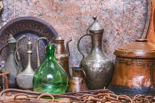 Glass bottles and copper and tin tea pots for sale at an outdoor market in Kruje.