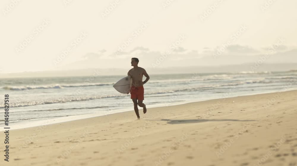Surfer running on the beach at sunset Surfer running on the beach at sunset