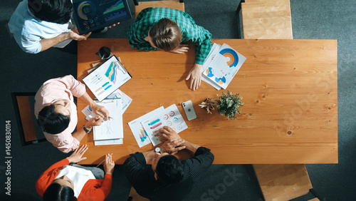 Obraz na płótnie Top view of business man using tablet display increasing graph while diverse marketing people sharing idea or planing strategy at meeting table with stock market statistic scatter around. Convocation. w salonie