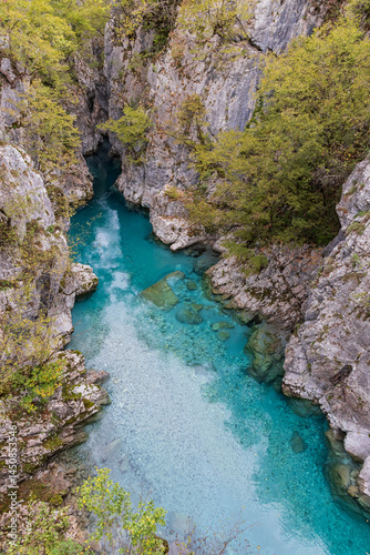Clear aque blue water of the Valbonas River in a rocky canyon.