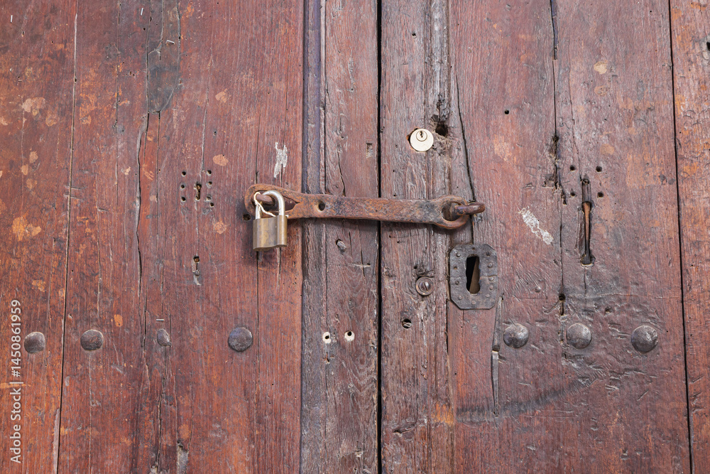 Padlock on an old wooden door.