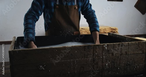 Super Slow Motion of Traditional Handmade Paper Making Process with Wooden Frame Being Lifted from Water Vat in Artisan Workshop Showing Wet Pulp Sheet Formation at 1000 fps.