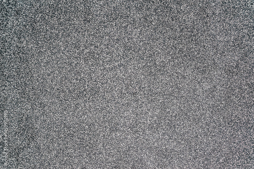 Close-up texture of a wall made of fine granite chips in black and white. House facade decor background.