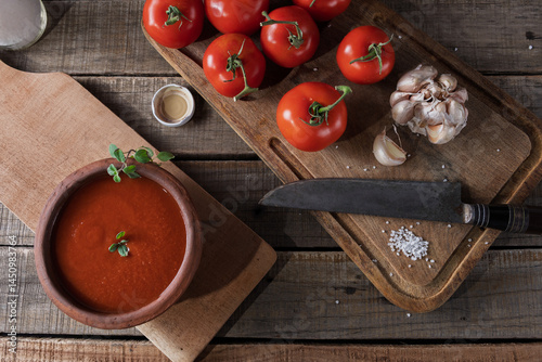 Top view of tomatoes and garlic for sauce preparation in a rustic setting.