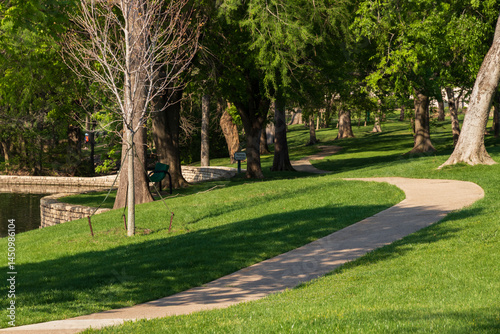 Winding concrete walking path through a lush green public park