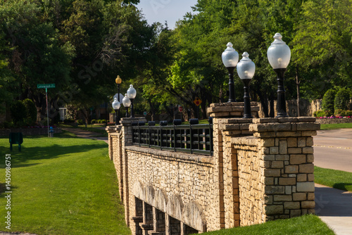 Obraz na plátně Classic Stone Bridge with Globe Lamp Posts in a Green Suburban Park in Plano Tex