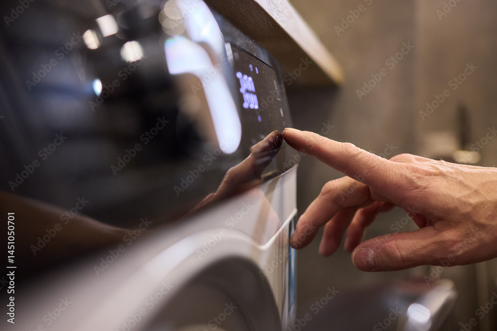 Individual Interacting with a Modern Washing Machines Control Panel for Efficient Laundry Tasks