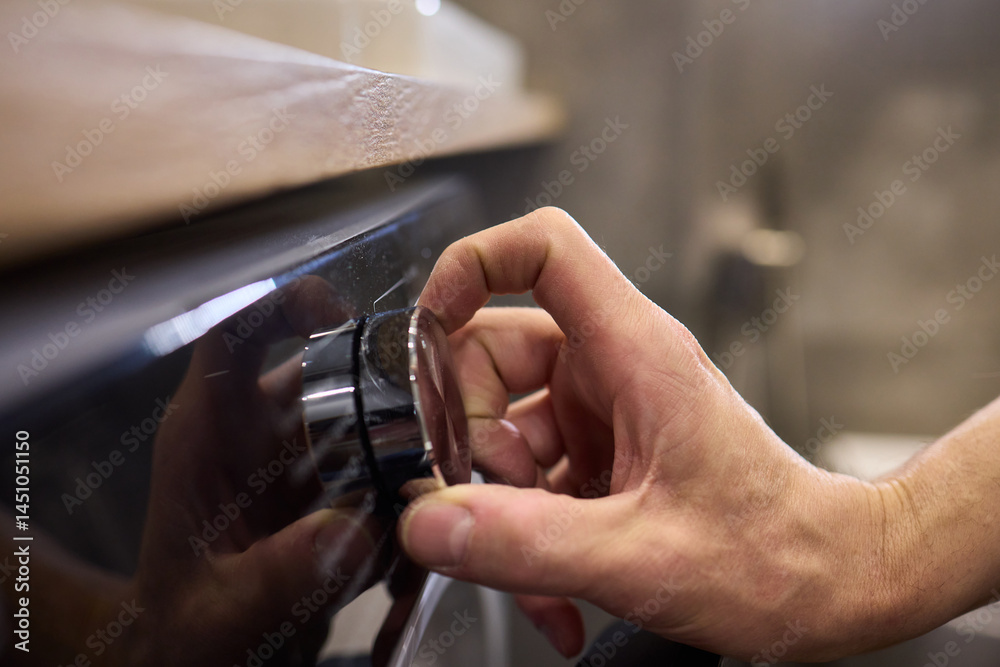 Individual Interacting with a Modern Washing Machines Control Panel for Efficient Laundry Tasks
