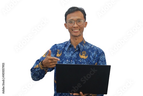 An Asian man wearing an Indonesian civil servant uniform holding a laptop showing a happy expression