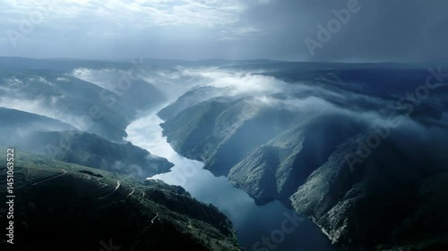 Wallpaper Mural Aerial view of dramatic river canyon winding through misty mountain landscape under moody skies in shaded blue Torontodigital.ca