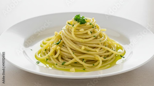 Traditional spaghetti aglio e olio served on a ceramic plate over a light, neutral background. Golden garlic slices and olive oil coat the pasta, creating a simple yet flavorful Italian dish
