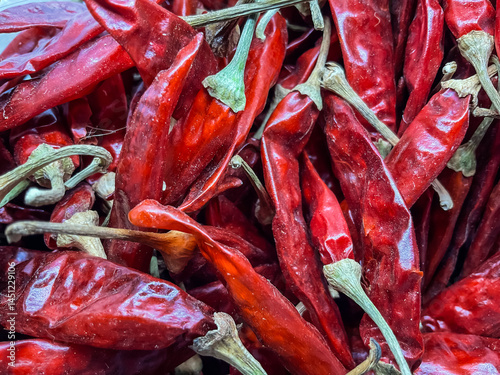 dried red chili peppers, bright red color, slender shape, and thin skin.