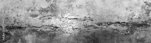 Textured concrete wall with cracks, monochrome abstract background.