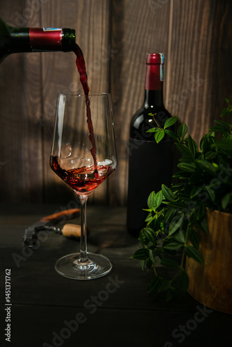 Pouring red wine into wine glass. Wine bottle openers