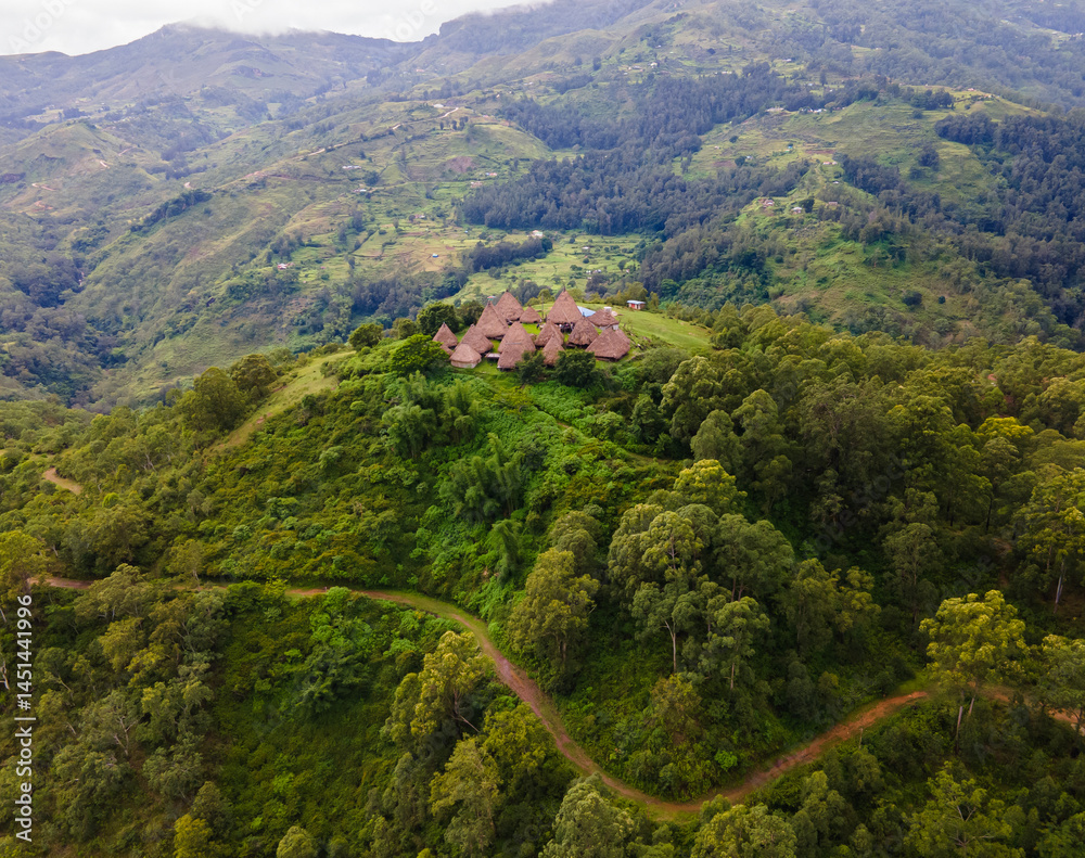 Aerial view of a complex of traditional houses in one of the villages in the Aileu Municipality in Timor Leste located in a hilly area. Still actively inhabited by locals and a tourist attraction.