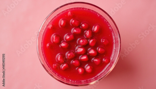 Glass of fresh pomegranate juice filled with vibrant seeds, showcasing rich red hue and refreshing appearance
