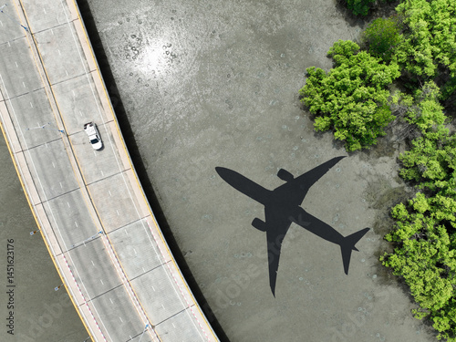 Obraz na płótnie Airplane shadow flying over mangrove forest with car driving on coastal concrete bridge. Sustainable aviation biofuel technology. Environmental conservation. Eco-friendly flight. Mangroves capture CO2 w salonie