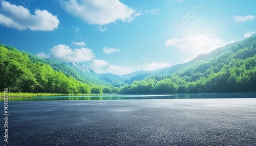 Serene mountain lake vista with paved road foreground. Lush greenery, tranquil water, and a clear sky create a picturesque scene