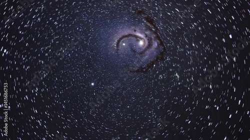 Spiraling galaxy with star trails in night sky captured in timelapse sequence