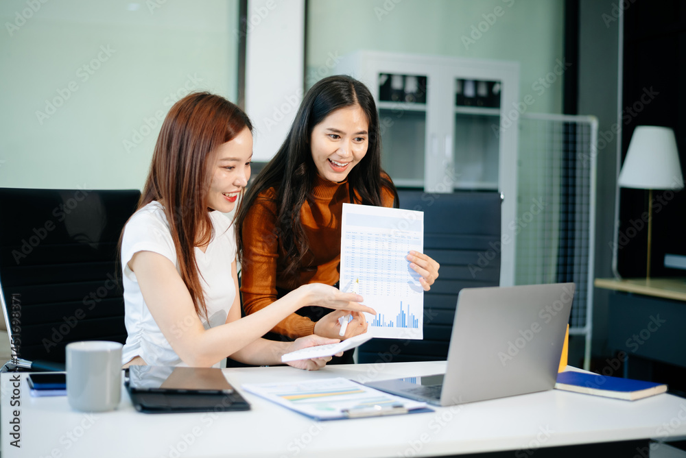 wo business women using laptop, standing and talking about analyzing documents in Teamwork Finance, Marketing wo business women using laptop, standing and talking about analyzing documents in Teamwork Finance, Marketing