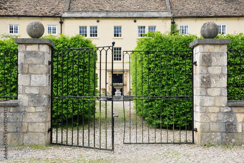 Gated entrance to a beautiful old mansion house on a street in an English town