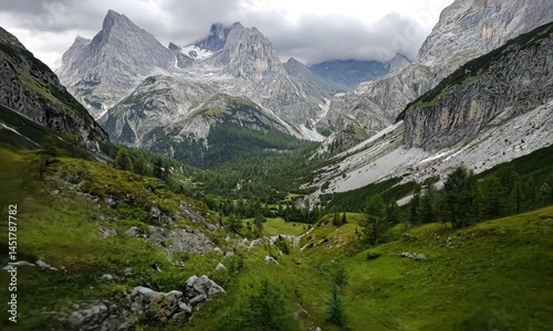 Majestic mountain valley, lush green meadows, and rugged peaks