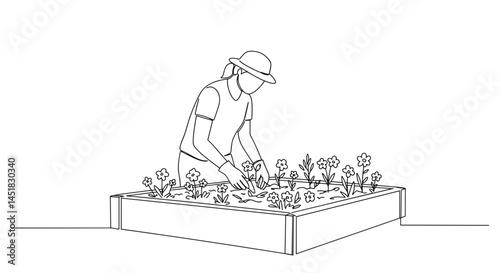 Gardener tending flowers in raised bed garden  