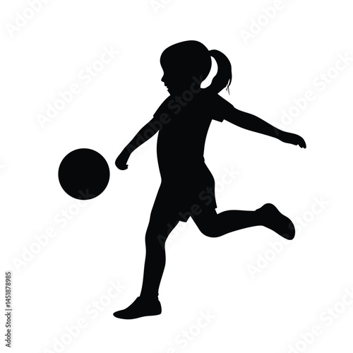 Silhouette of a young girl playing soccer, kicking the ball