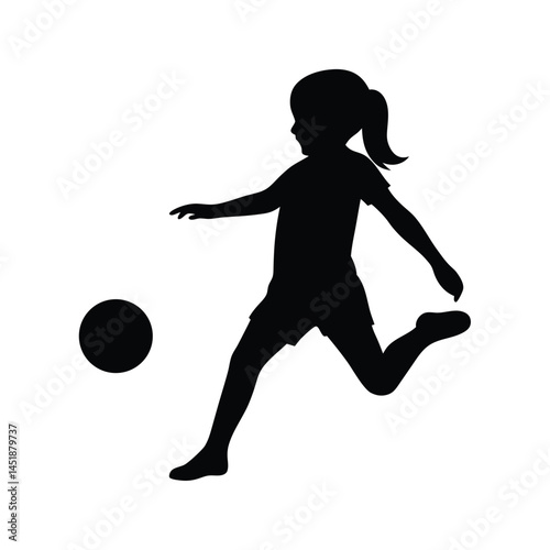 Silhouette of a young girl playing soccer, kicking the ball