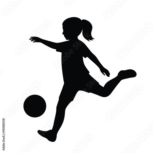 Silhouette of a young girl playing soccer, kicking the ball