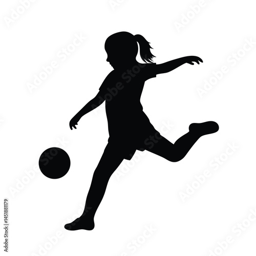 Silhouette of a young girl playing soccer, kicking the ball