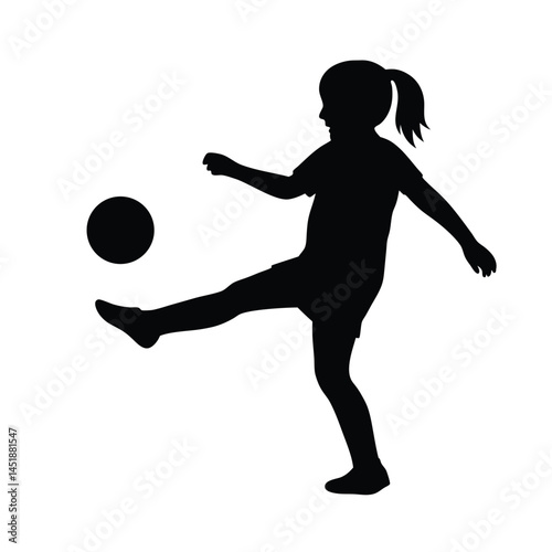 Silhouette of a young girl playing soccer, kicking the ball