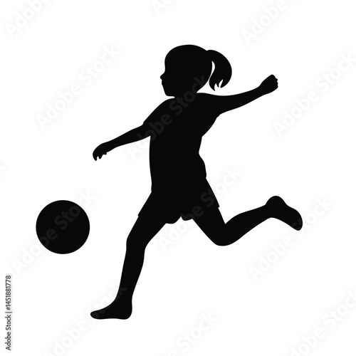 Silhouette of a young girl playing soccer, kicking the ball