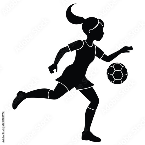 Silhouette of a young girl playing soccer, kicking the ball
