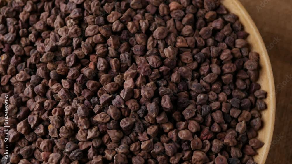Raw Dark Brown Chickpeas (Kala Chana) on a rustic wooden table. Dry Balck chickpea (ceci neri) background close up. 